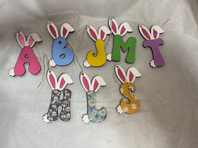 Colorful wooden letters with bunny ears on a gray background